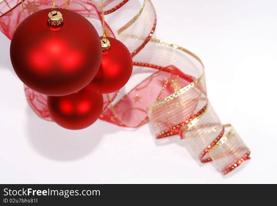 Hanging red glass balls with the ribbon on the white background. Hanging red glass balls with the ribbon on the white background