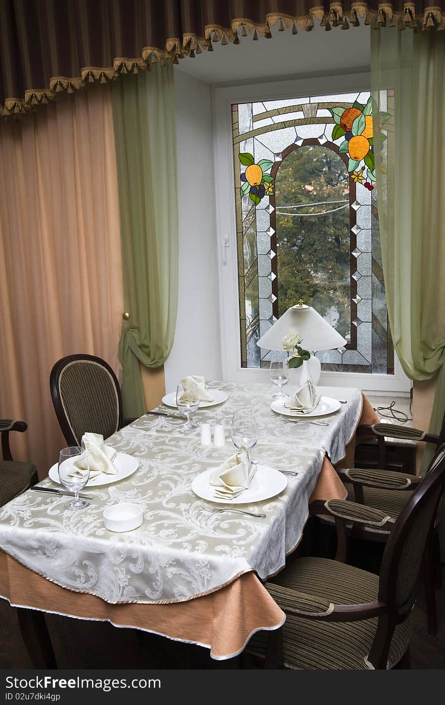 Restaurant interior: a dining table, chairs and a window with a kind on street