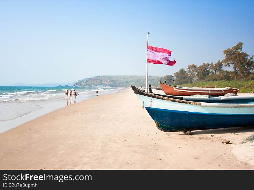 Wooden outrigger fishing boat with flag at Arambol (Harmal) beach, Goa India