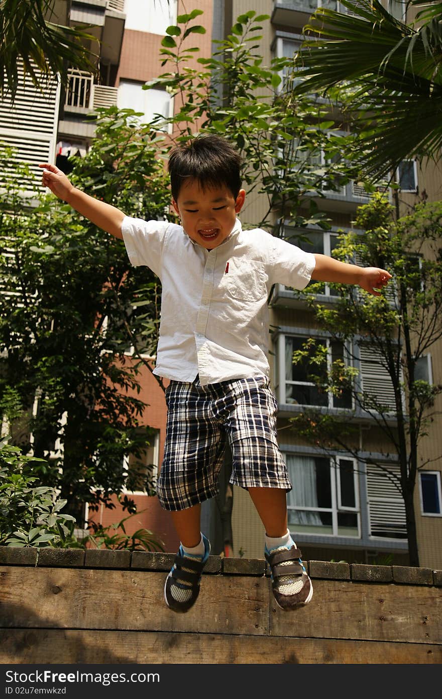 Picture of a little chinese boy jupming happily and having great fun. Picture of a little chinese boy jupming happily and having great fun