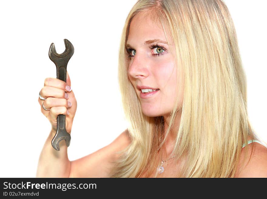 Studio photo, portrait of beautiful blond girl holding spanner. Studio photo, portrait of beautiful blond girl holding spanner