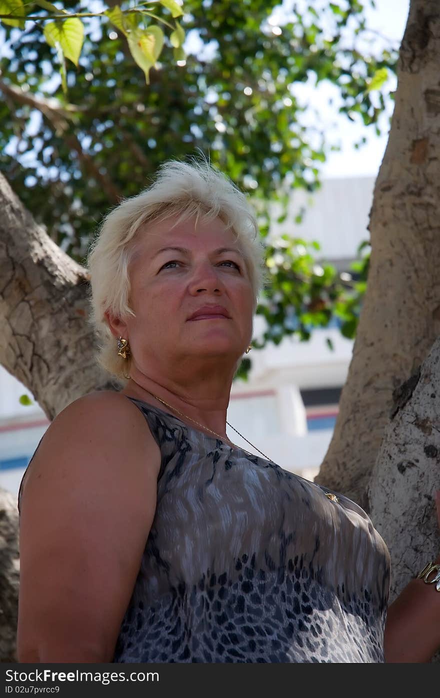 Casual portrait of happy mature woman against  the background of the tree. Casual portrait of happy mature woman against  the background of the tree.