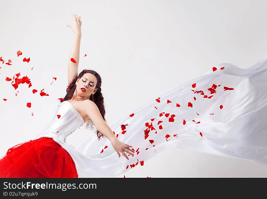 Young beautiful woman with petals of roses, on a white background