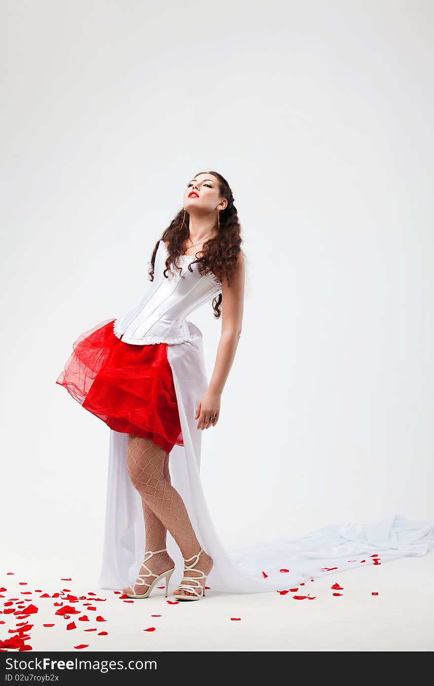 Young beautiful woman with petals of roses, on a white background