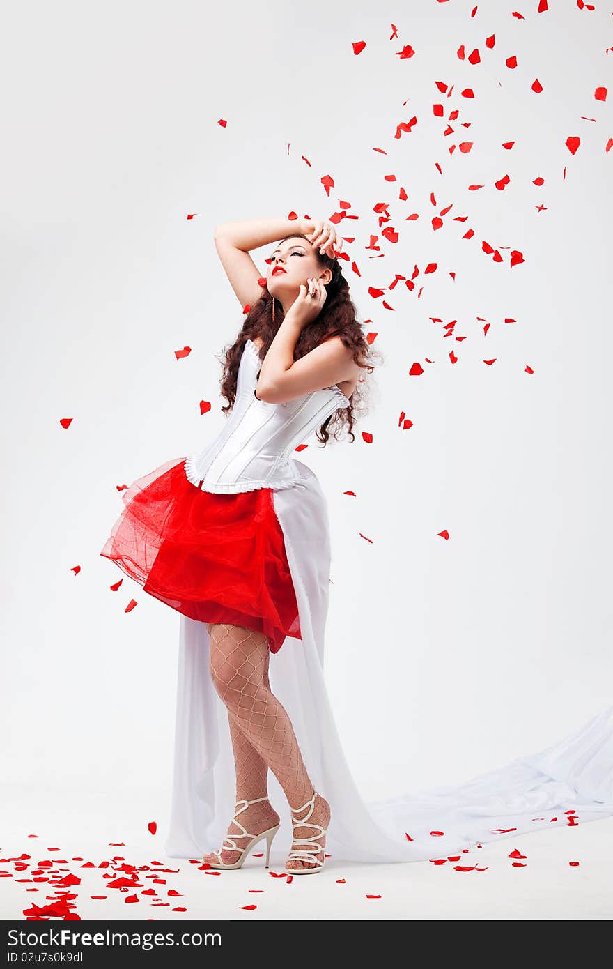 Young beautiful woman with petals of roses, on a white background