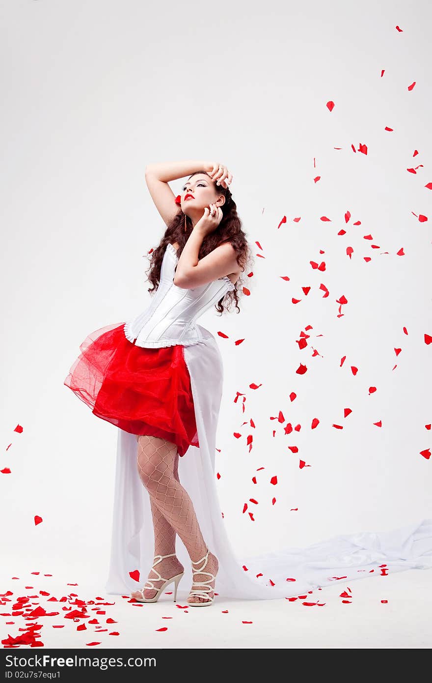 Young beautiful woman with petals of roses, on a white background