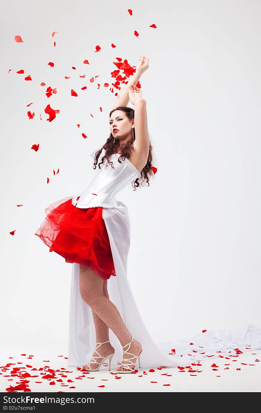 Young beautiful woman with petals of roses, on a white background