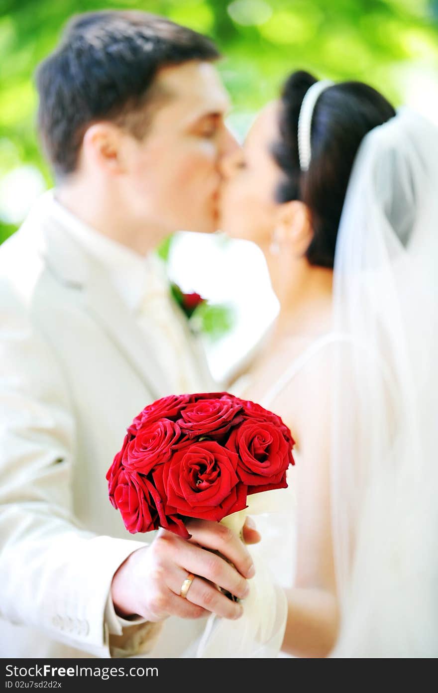 Groom and bride in white dress on background of green trees. Groom and bride in white dress on background of green trees