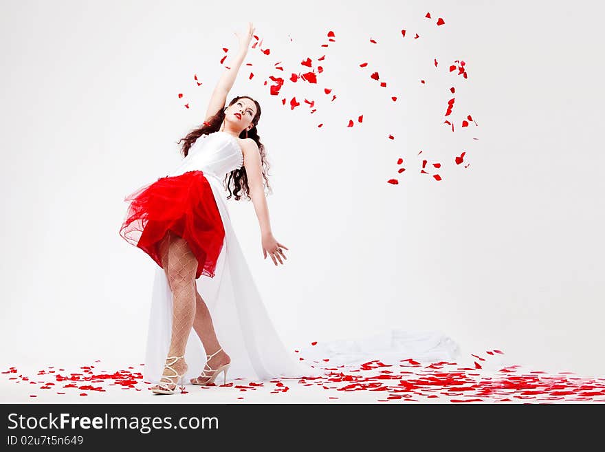 Young beautiful woman with petals of roses, on a white background