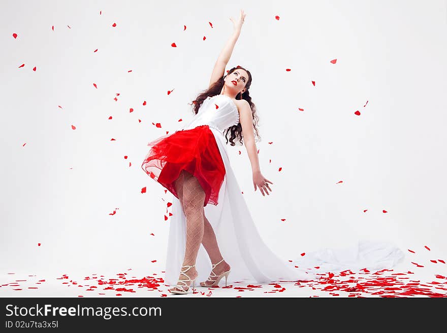 Young beautiful woman with petals of roses, on a white background