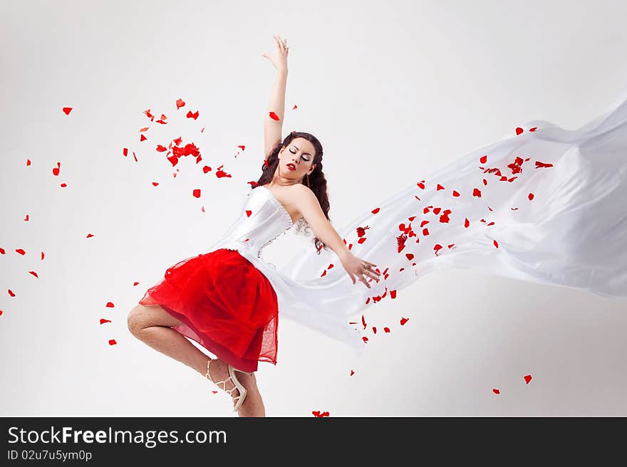 Young beautiful woman with petals of roses, on a white background