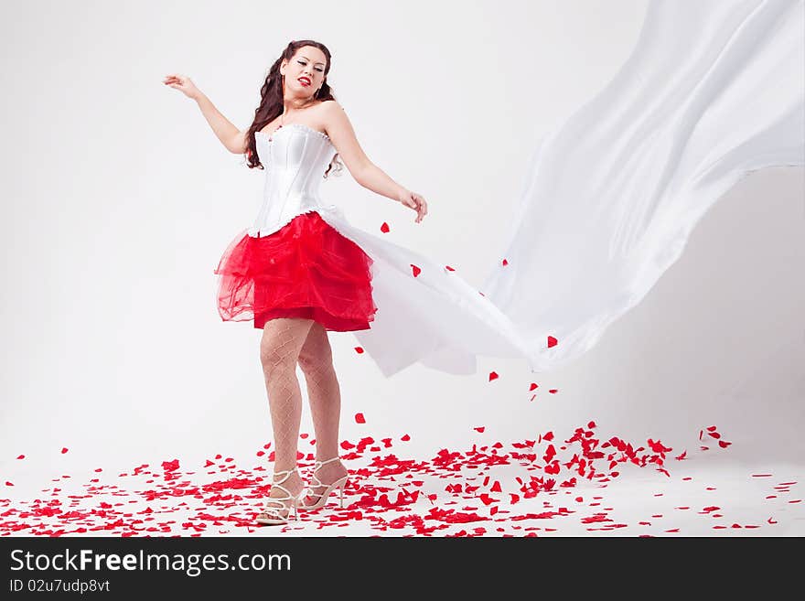 Young beautiful woman with petals of roses, on a white background