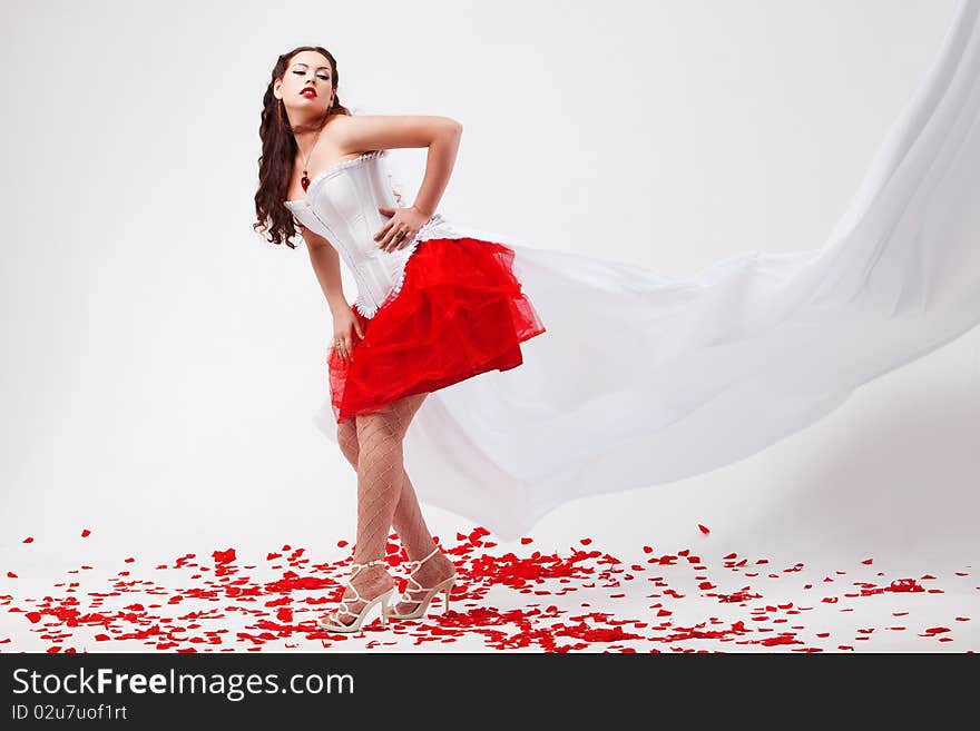 Young beautiful woman with petals of roses, on a white background