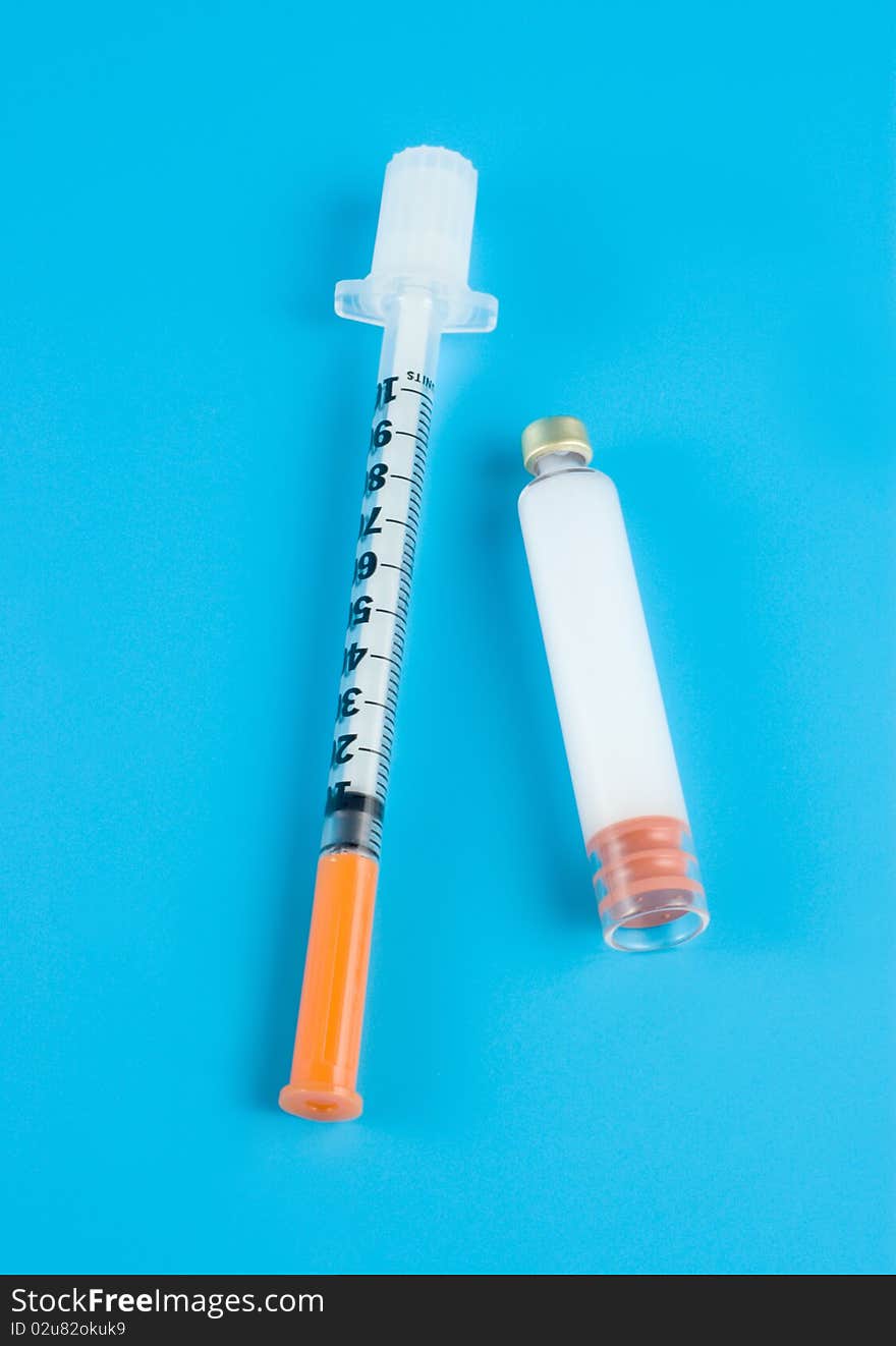 Insulin and syringe on a blue background