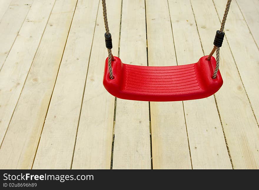 A lonely red children's swing