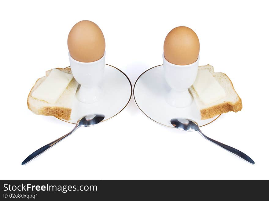 Eggs with bread and butter are on the white background