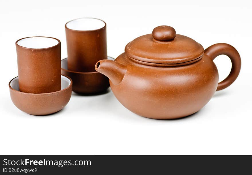 Clay tea pot and cups on a white background