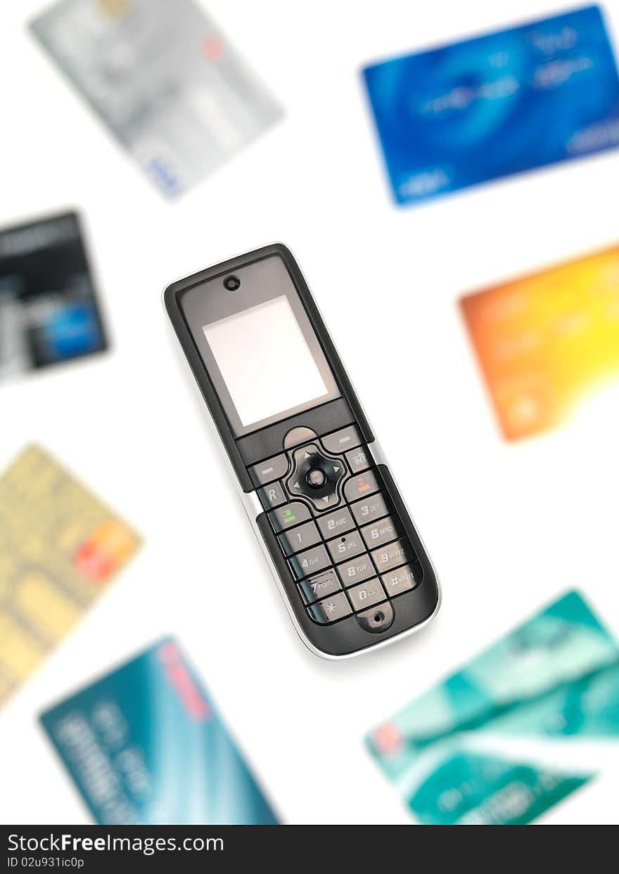 A cordless telephone isolated on a white background with credit cards. A cordless telephone isolated on a white background with credit cards