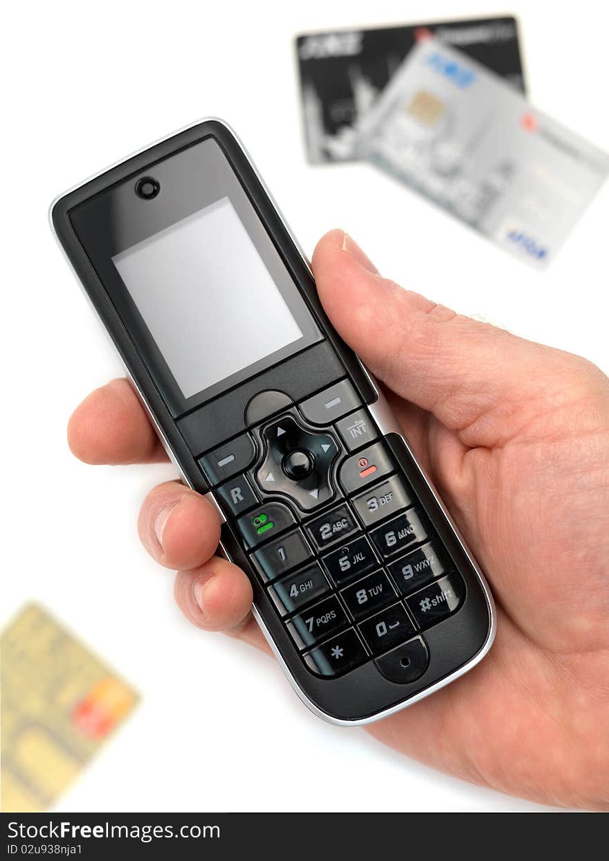 A cordless telephone isolated on a white background with credit cards. A cordless telephone isolated on a white background with credit cards