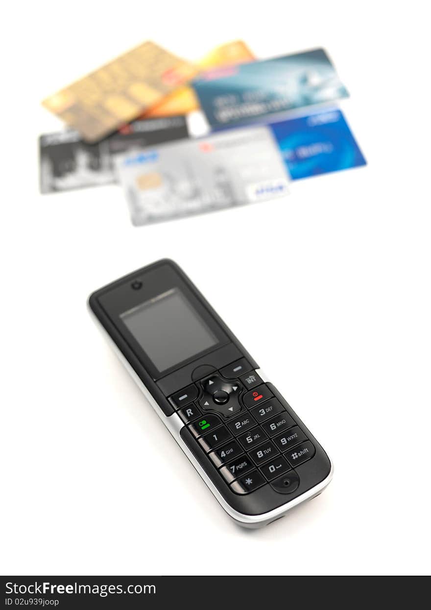 A cordless telephone isolated on a white background with credit cards. A cordless telephone isolated on a white background with credit cards