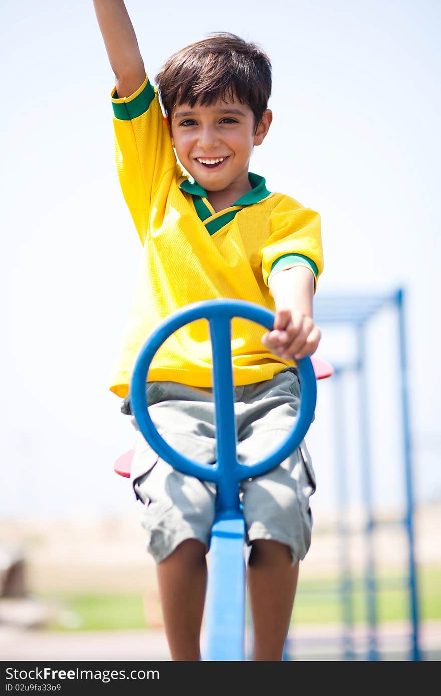 Boy in soccer uniform playing in the park and taking ride on swing. Boy in soccer uniform playing in the park and taking ride on swing