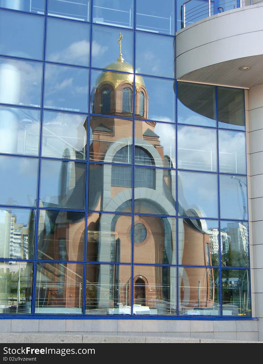 Church reflexion in windows of a modern building