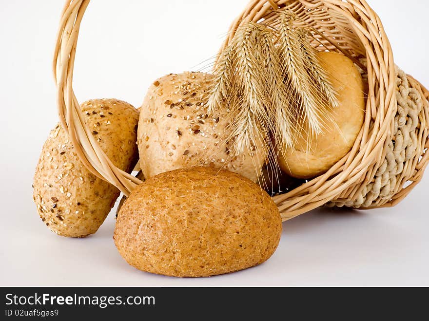 Basket turned over with the fresh bread on the white background. Basket turned over with the fresh bread on the white background