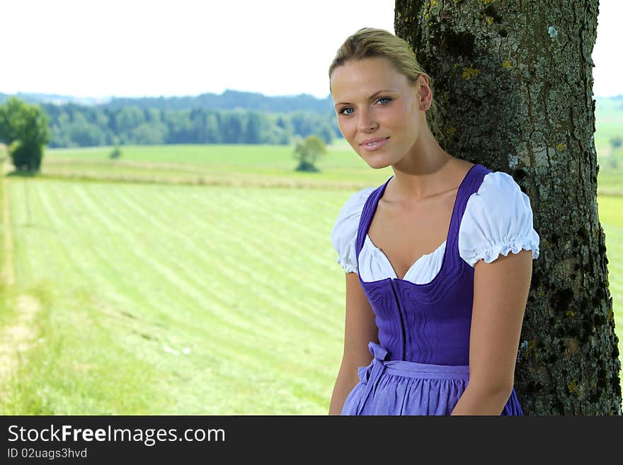 Beautiful bavarian Girl standing by a tree