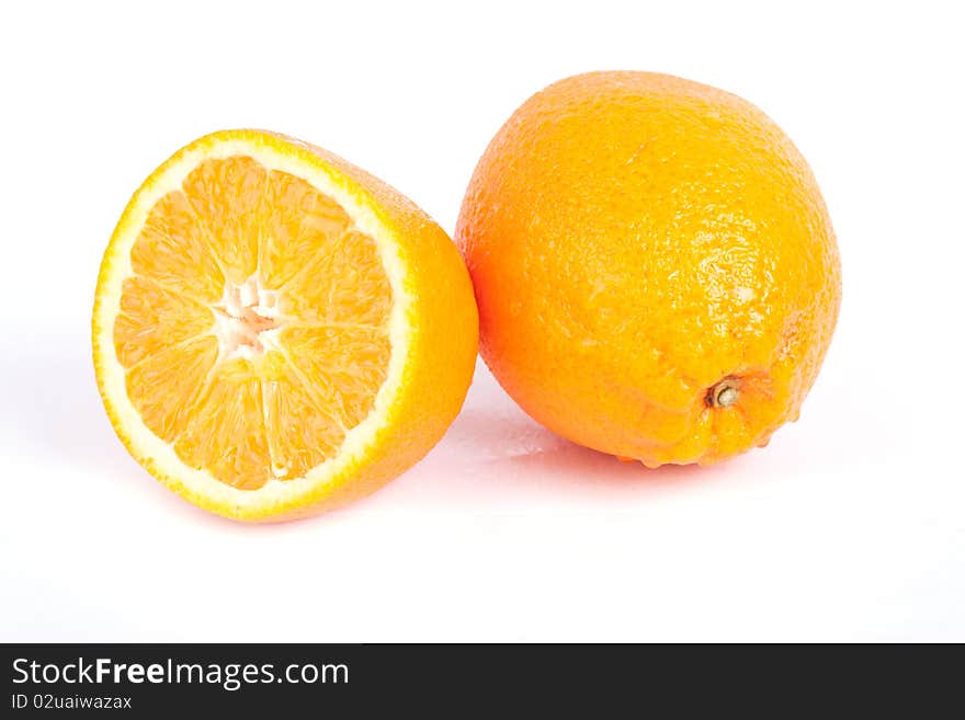 Ripe sliced and whole orange with water drops isolated on white background.