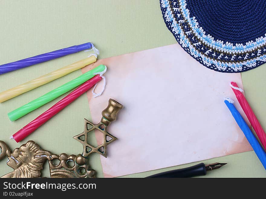 Menorah and a blue kippah next to an old piece of paper. Add your text to the paper. Menorah and a blue kippah next to an old piece of paper. Add your text to the paper.