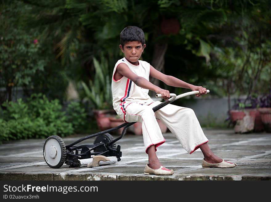 Small boy playing with grass cutter in garden. Small boy playing with grass cutter in garden.