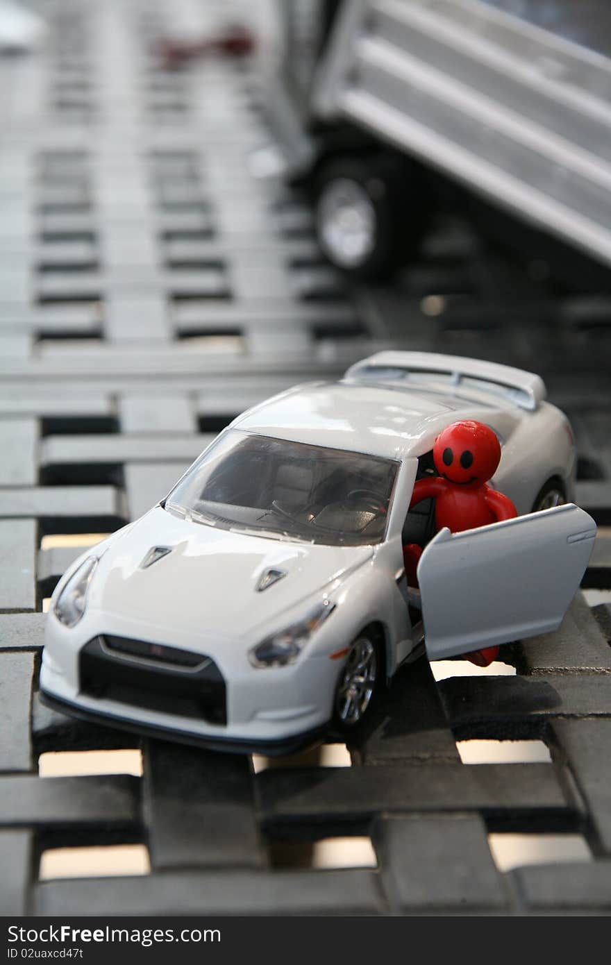 A red smiley face driver getting out of his car with a truck in the background. A red smiley face driver getting out of his car with a truck in the background.