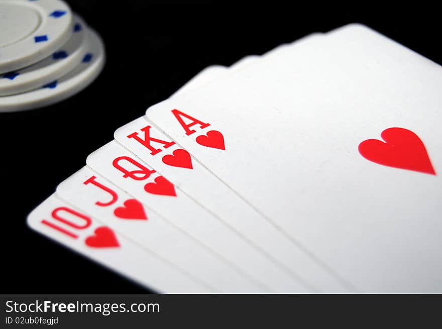 Royal Flush of Hearts on black background with White Poker Chips. Royal Flush of Hearts on black background with White Poker Chips