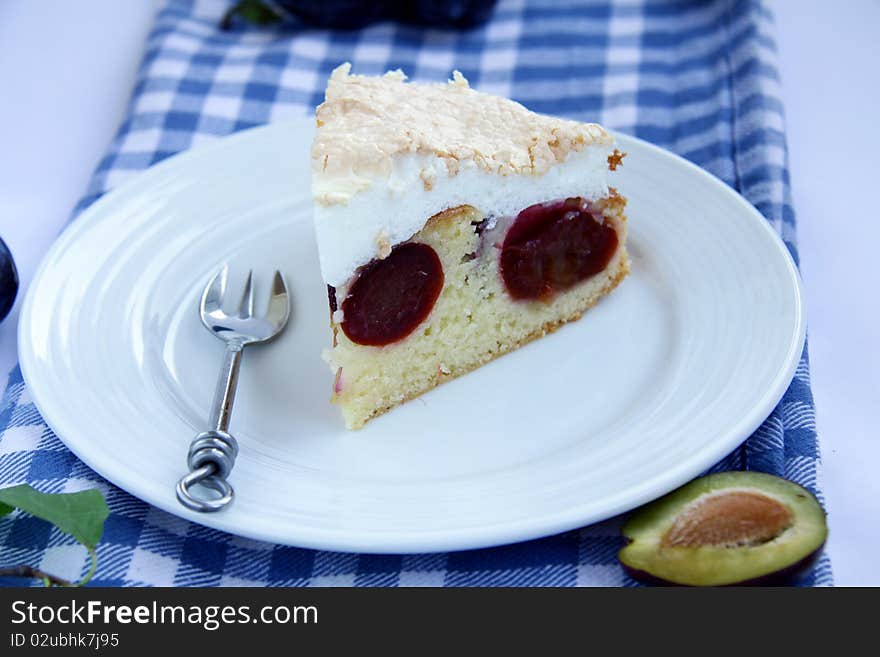 A beautiful piece of plum cake on a plate with a blue cloth. A beautiful piece of plum cake on a plate with a blue cloth