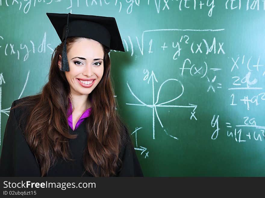 Educational theme: graduating student in academic gown in a classroom. Educational theme: graduating student in academic gown in a classroom.