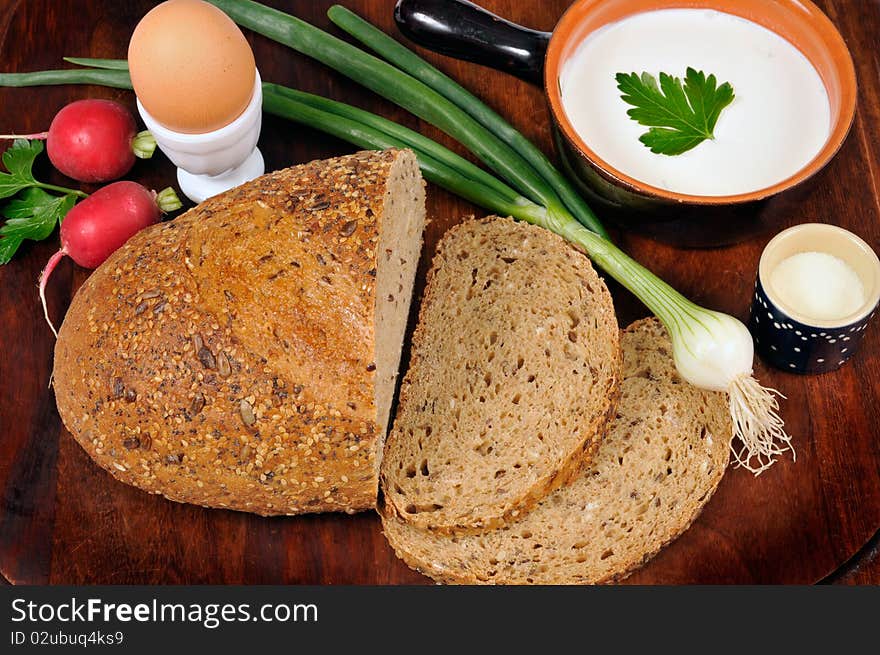 Loaf of bread with vegetables, sour cream and egg on the tablet. Loaf of bread with vegetables, sour cream and egg on the tablet