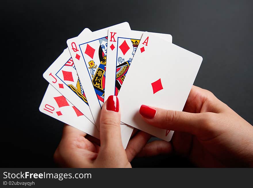 Diamonds Royal Flush in Female Hands isolated on a black background