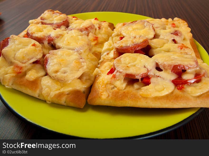 Pizza on green plate on table close up