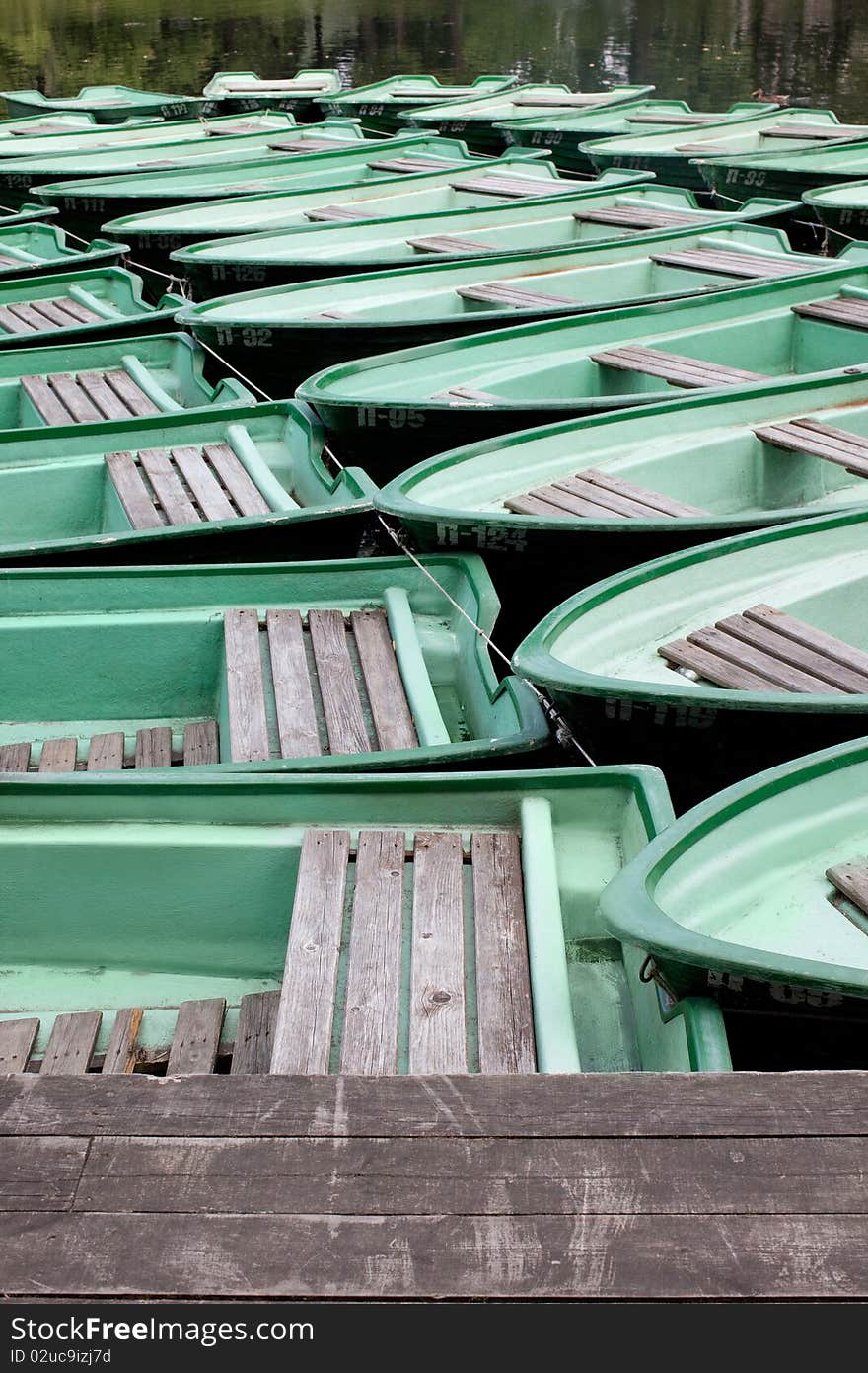 Green boat on the water near the pier