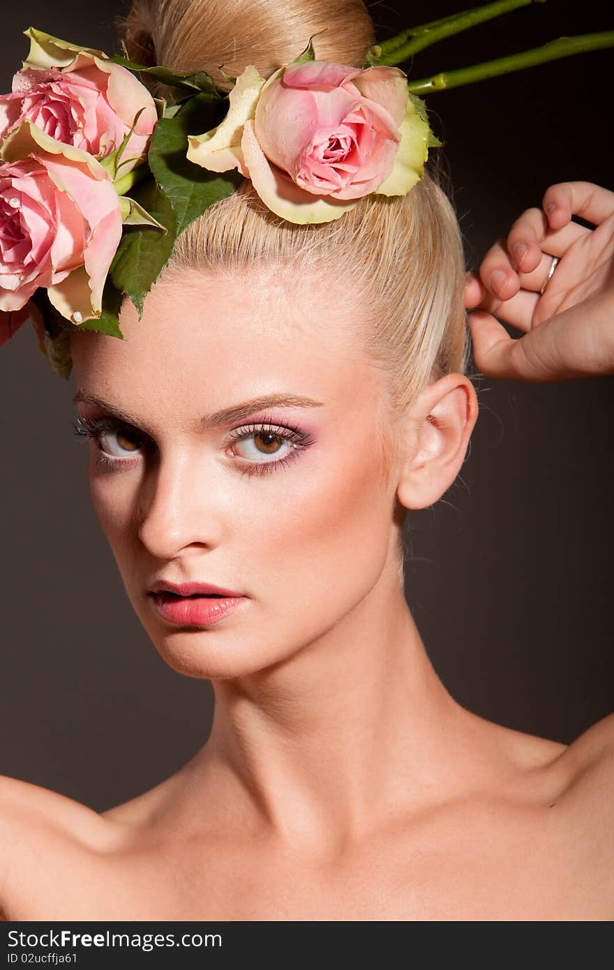 Portrait of beautiful blonde with a wreath of flowers on her head on the grey background. Portrait of beautiful blonde with a wreath of flowers on her head on the grey background