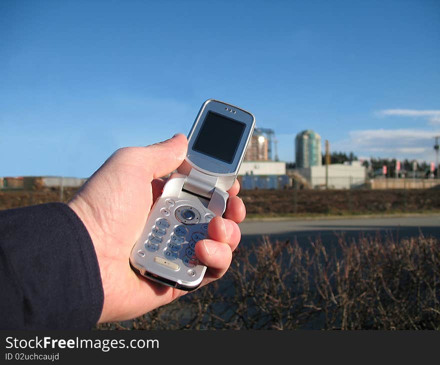 Mobile phone held by hand with a clear blue sky in the background. Mobile phone held by hand with a clear blue sky in the background.