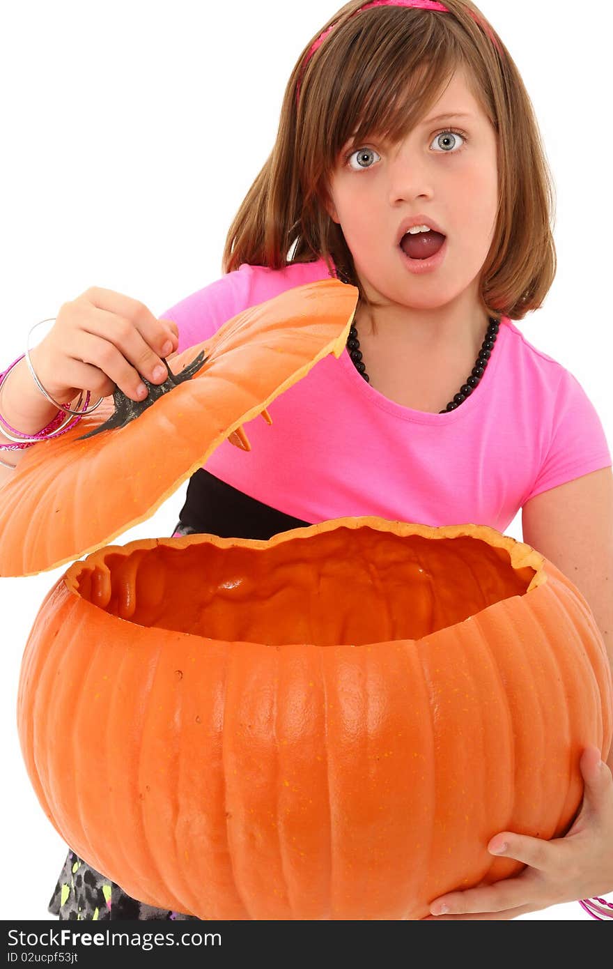 Beautiful 10 year old girl with giant empty pumpkin and surprised expression over white background. Beautiful 10 year old girl with giant empty pumpkin and surprised expression over white background.