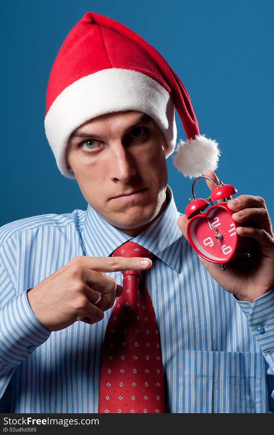 Yuong man in red christmas hat and alarm clock