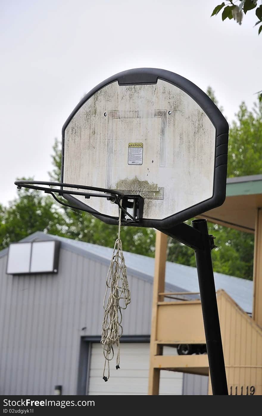 Old and worn out basketball board and hoop. For sports and recreation, and health and fitness concepts. Old and worn out basketball board and hoop. For sports and recreation, and health and fitness concepts.