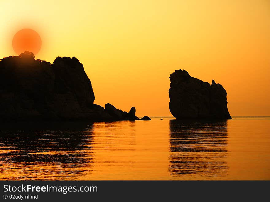 Sunset on the beach, behinde the rocks