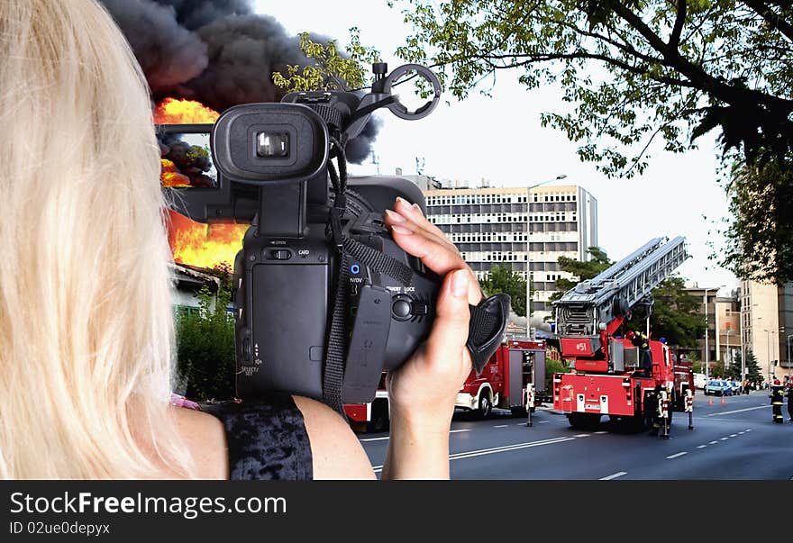 Woman videographer recording big fire in the city. Woman videographer recording big fire in the city