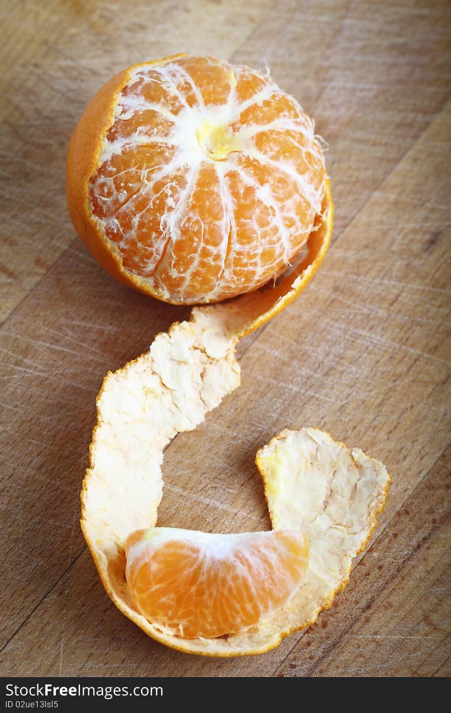 Tangerine with peeled on the wooden background. Tangerine with peeled on the wooden background