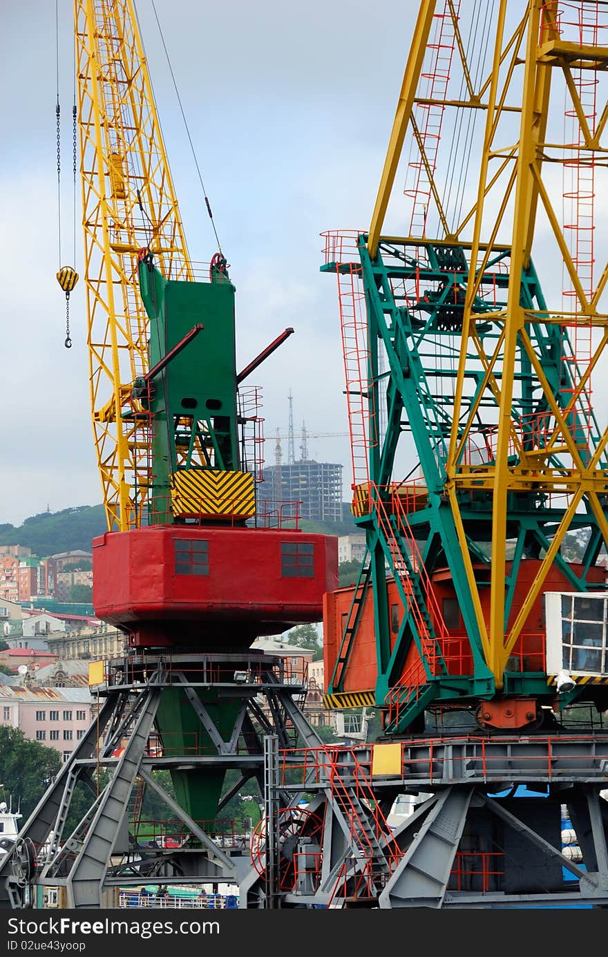 Two colored girder cranes in city port. Two colored girder cranes in city port