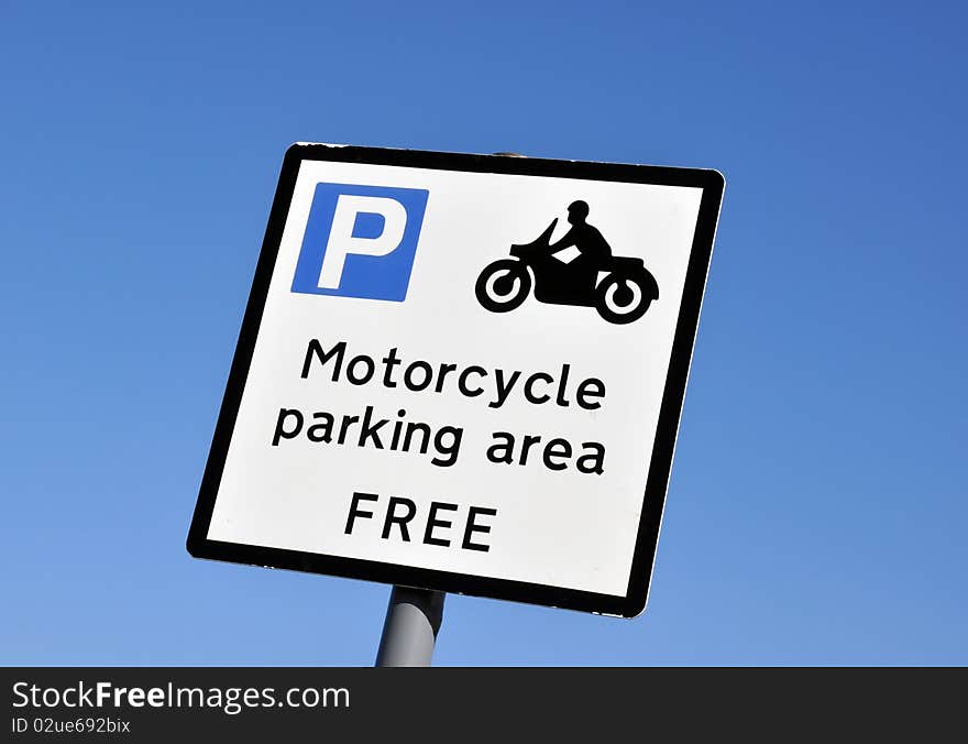 Motorcycle parking area sign against cloudless blue sky. Motorcycle parking area sign against cloudless blue sky