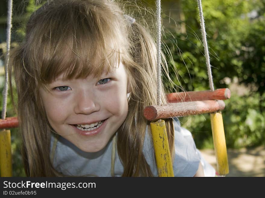 Cheerful girl on a swing